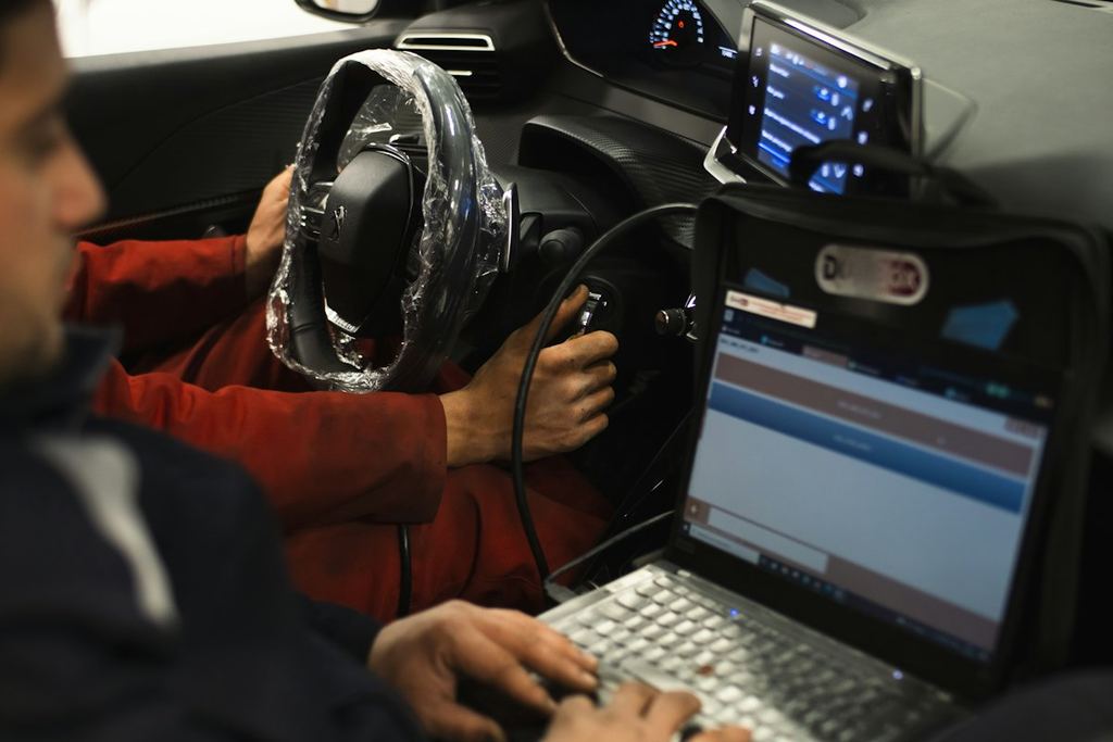 A technician running a scan tool inside a car