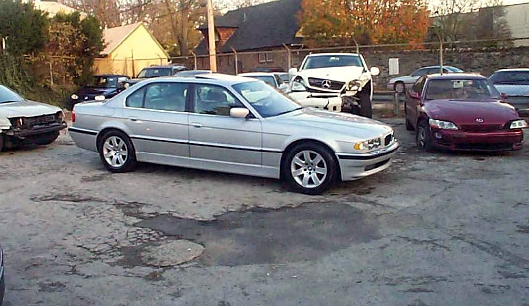 A finished silver BMW parked outside the shop, ready for pickup