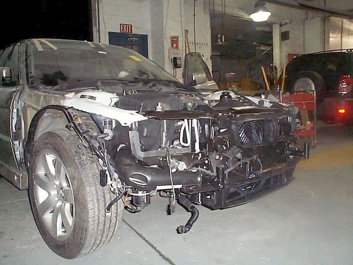 A silver BMW sedan in our shop with its front end taken apart for collision repair