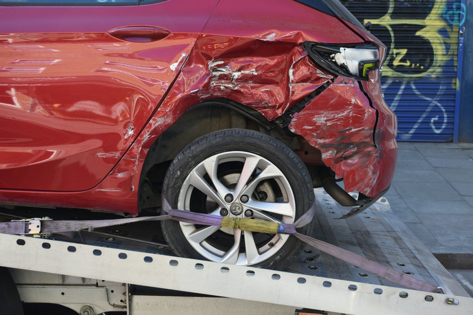 A damaged car on a flatbed tow truck