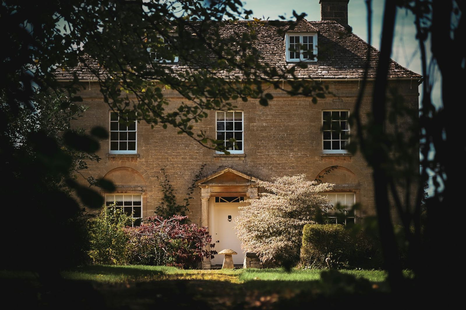 A stone house on a tree-lined street