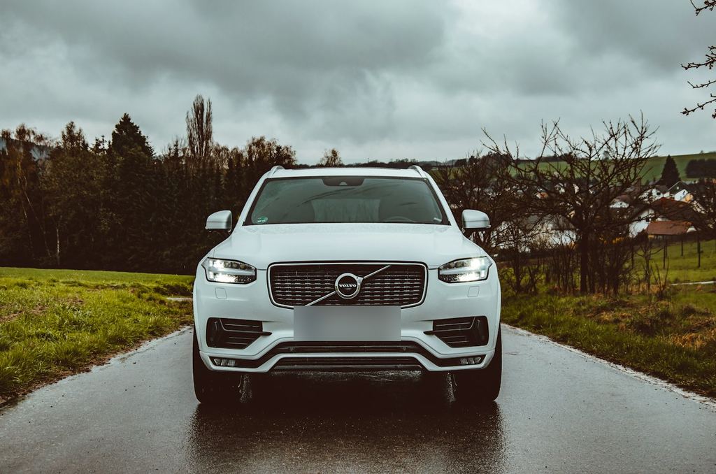 A white Volvo SUV on a country road